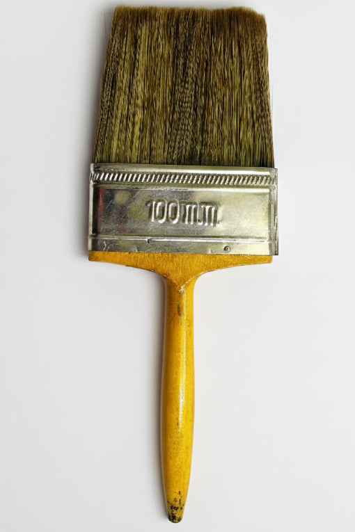 Paintbrush with a wooden handle and metal ferrule on a white background